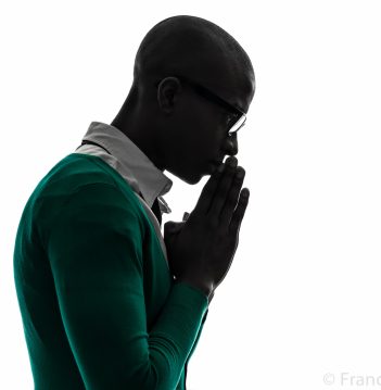 one african  black man  thinking pensive praying silhouette  in silhouette studio on white background