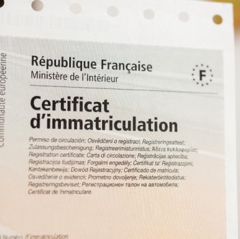 Paris: Detail of the vehicle registration certificate (certificat d'immatriculation known also as carte grise) with special holographic protection stamp issued by the Ministry of Interior of France. A vehicle registration certificate is an official document providing proof of registration of a motor vehicle